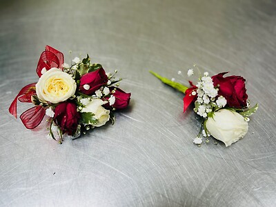 A Wrist corsage and boutonniere combination - red and white roses